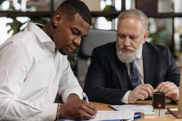 Two businessmen collaborating in an office setting, focused on document review and strategic planning. Reviewing a lead generation agency before any live engagement