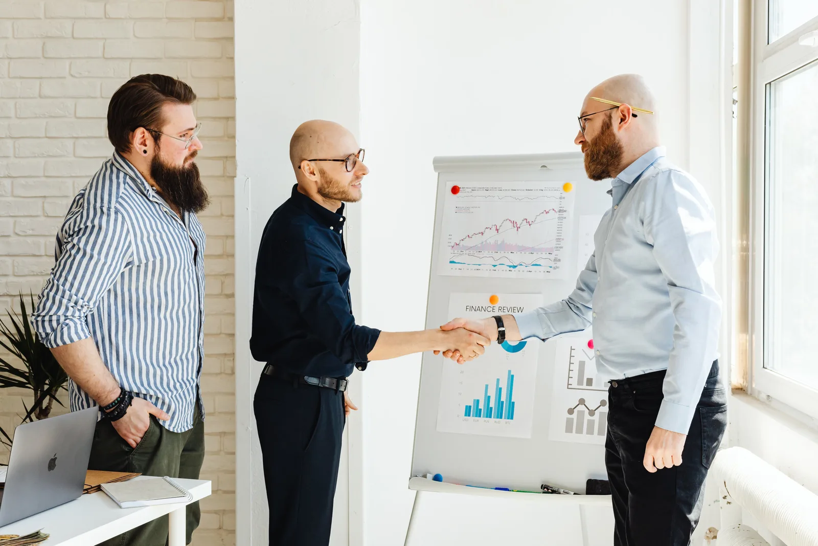 Three business colleagues engage in a productive meeting, exchanging ideas with data charts.