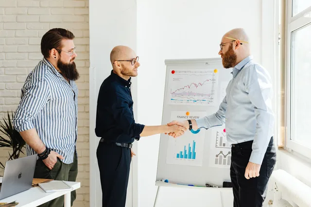 Three business colleagues engage in a productive meeting, exchanging ideas with data charts. Audience research for a lead network that separates both sides of the marketplace
