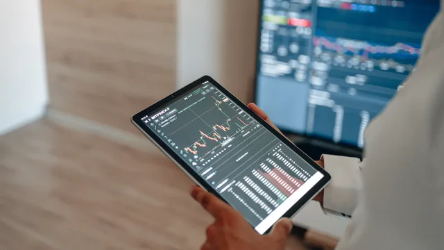 A person uses a tablet to monitor stock market trends and real-time trading graphs. Lead generation networks benchmark research: how to assess