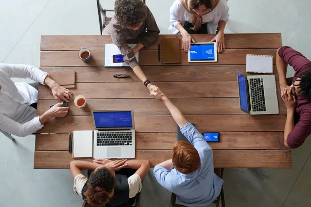 Overhead view of colleagues in a work meeting using laptops and tablets, emphasizing teamwork and technology. Reviewing lead networks starts with finding out who actually offers the service